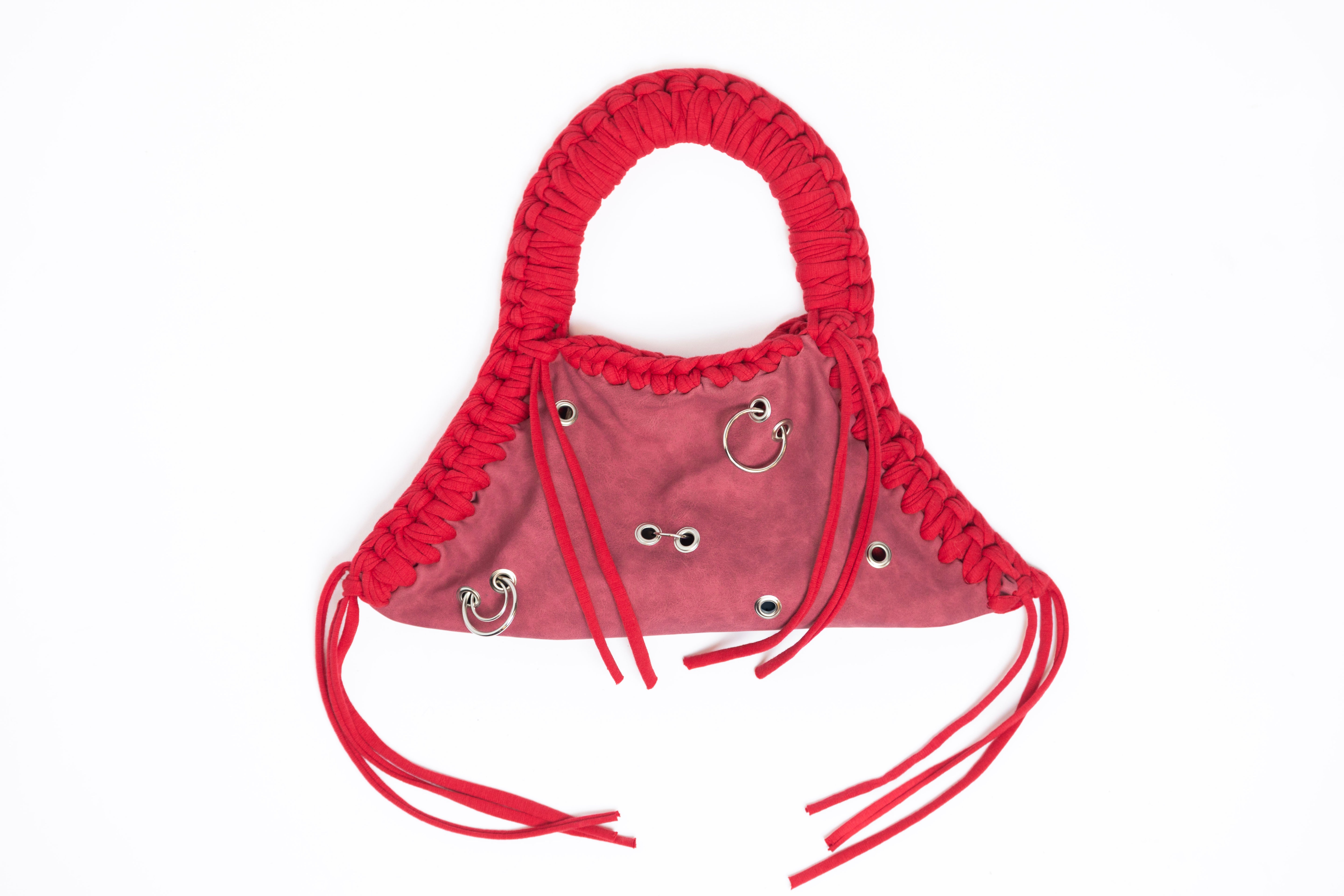 Red braided handbag with decorative elements on a white background