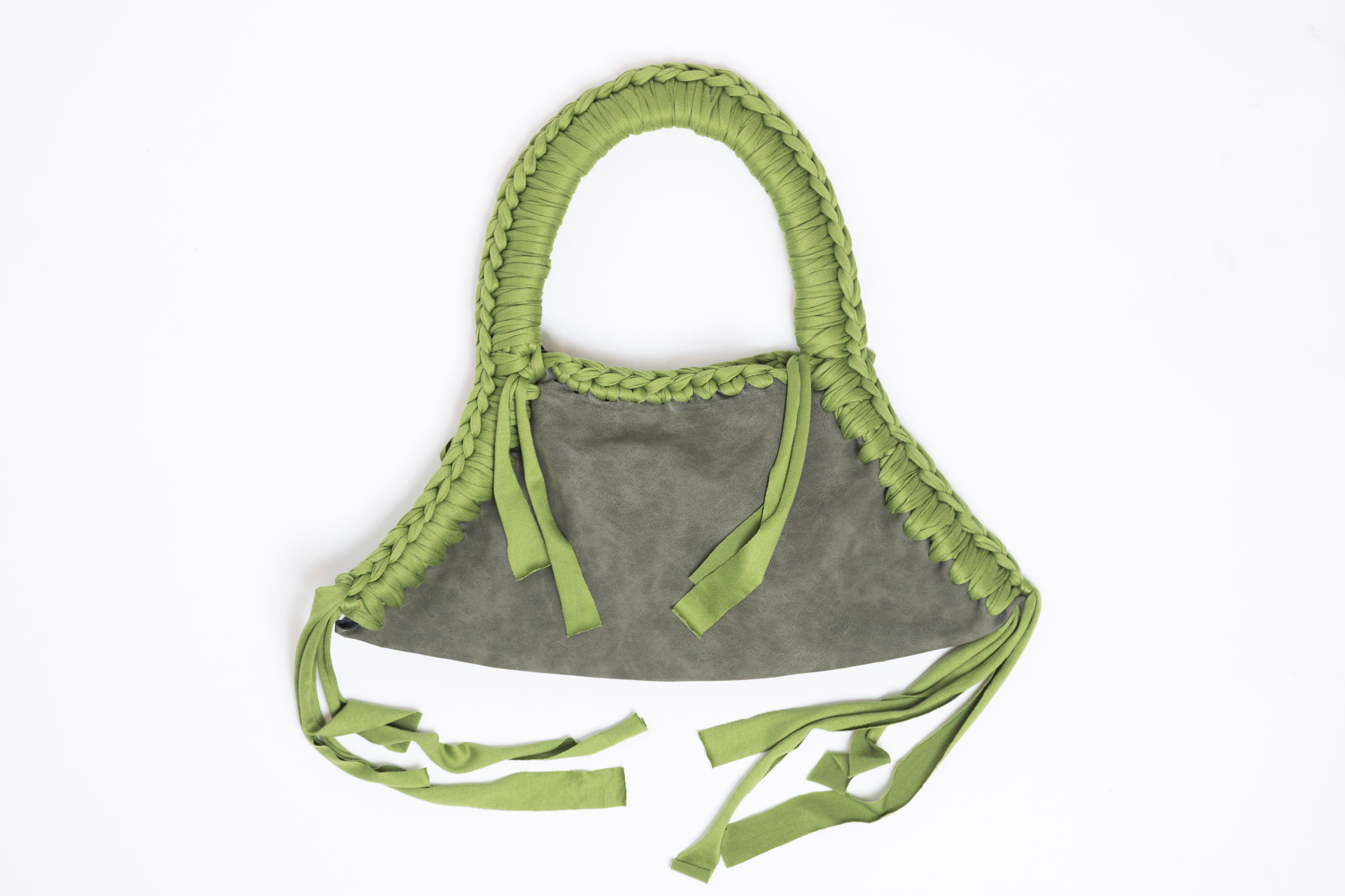 Gray bag with green braided handles on a white background